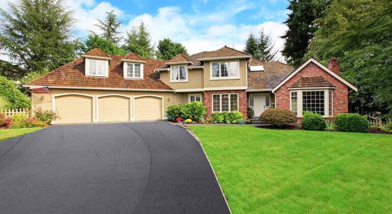 Beautifully maintained home and property by Artisan Outdoor Contractors LLC – landscaped yard and well-maintained asphalt driveway lined with hardscaping in Hunterdon County, NJ.